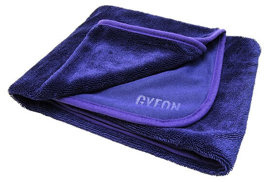 A neatly folded dark blue microfiber towel, ideal for car detailing, with a label or branding partially visible.